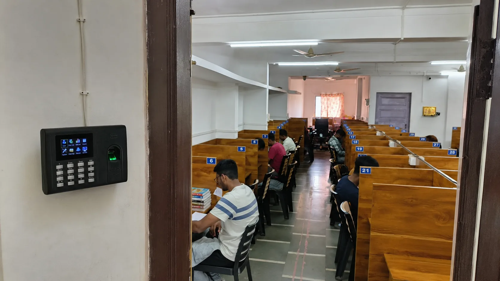 Student using a biometric fingerprint device at a study library entrance